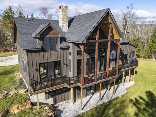 100 Morganite Way, Newry, ME 04261 - back of house featuring a shingled roof, a chimney, a lawn, board and batten siding, and a deck