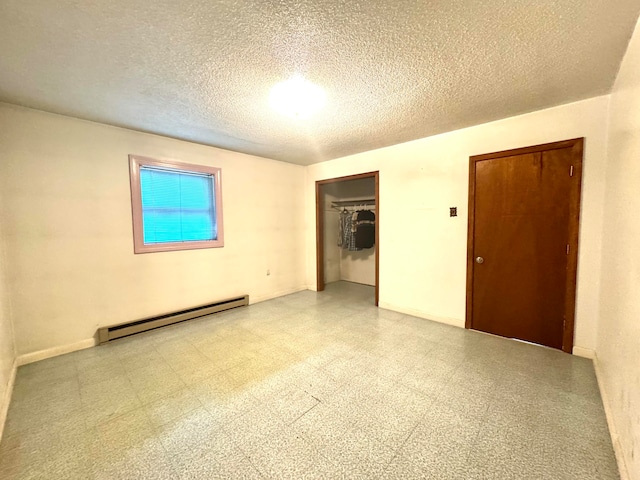 unfurnished bedroom with a baseboard heating unit, a textured ceiling, and a closet