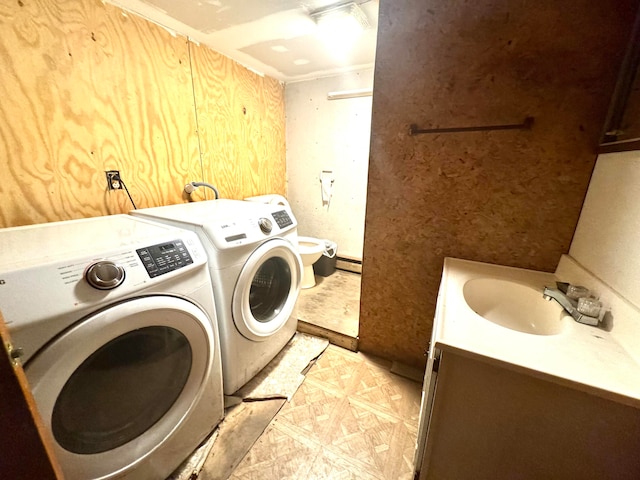 laundry room with sink, a baseboard heating unit, and washer and dryer