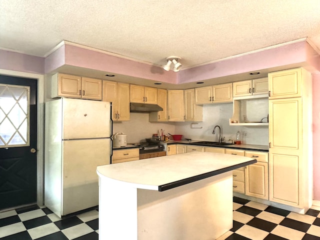 kitchen with a center island, a textured ceiling, sink, and refrigerator