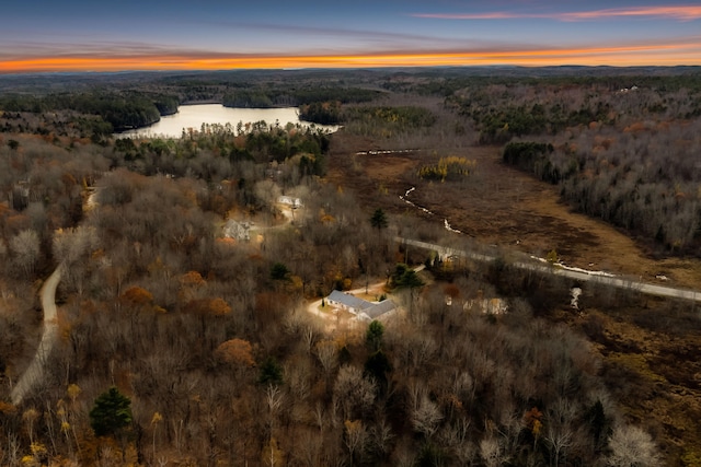 aerial view at dusk featuring a water view