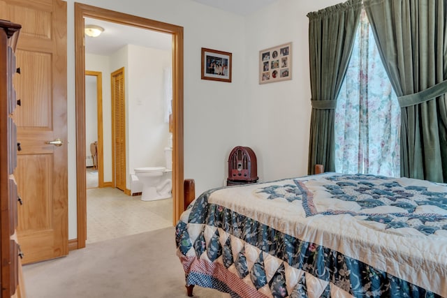 bedroom featuring light carpet and connected bathroom