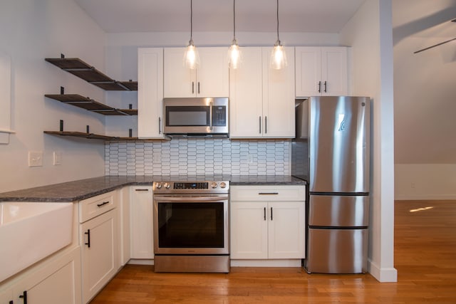 kitchen featuring appliances with stainless steel finishes, white cabinets, and tasteful backsplash