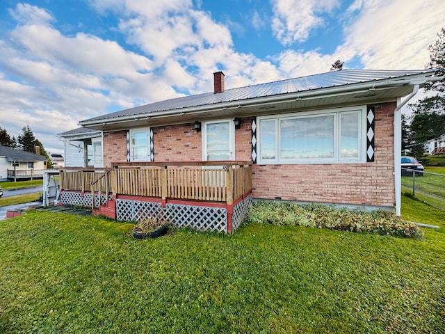 back of property with a deck and a lawn