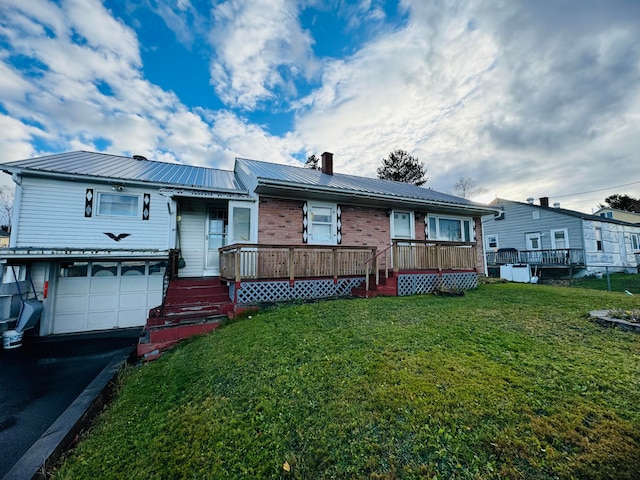 rear view of house featuring a garage and a lawn