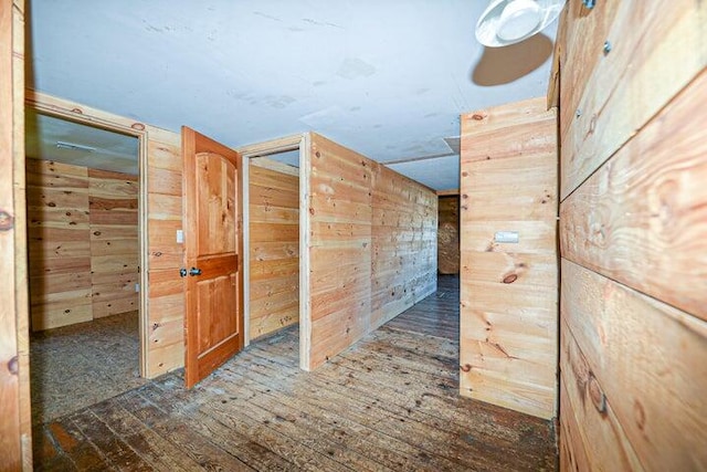 hallway with dark wood-type flooring and wood walls