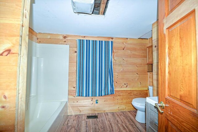 bathroom with vanity, toilet, wood walls, and hardwood / wood-style flooring