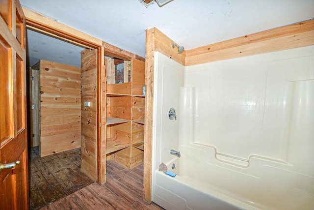 bathroom featuring  shower combination, wooden walls, and wood-type flooring