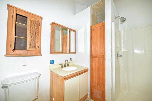 bathroom featuring toilet, walk in shower, and vanity