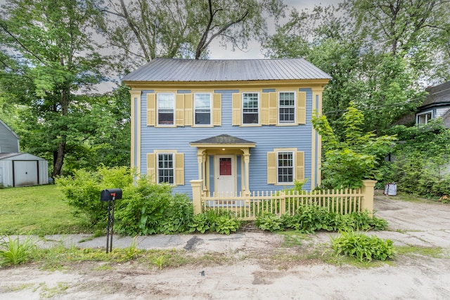 colonial home with a storage shed