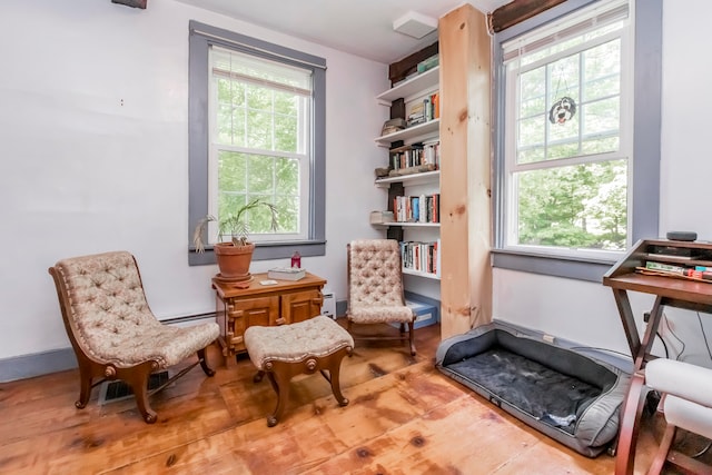 sitting room with baseboard heating and hardwood / wood-style floors