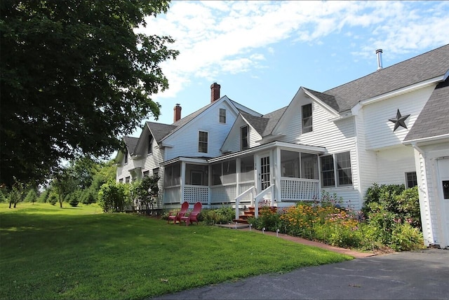 view of front of property with a front yard and a sunroom