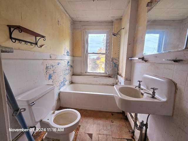 bathroom featuring tile walls, toilet, and shower / bathtub combination