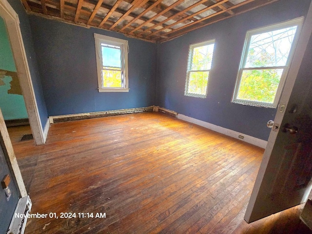 unfurnished room featuring a baseboard radiator and wood-type flooring