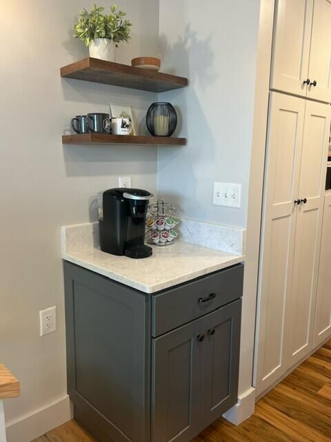 bar featuring gray cabinetry, dark wood-type flooring, and white cabinets