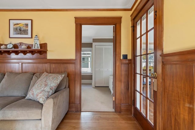 living room featuring a wealth of natural light, light wood-type flooring, and crown molding