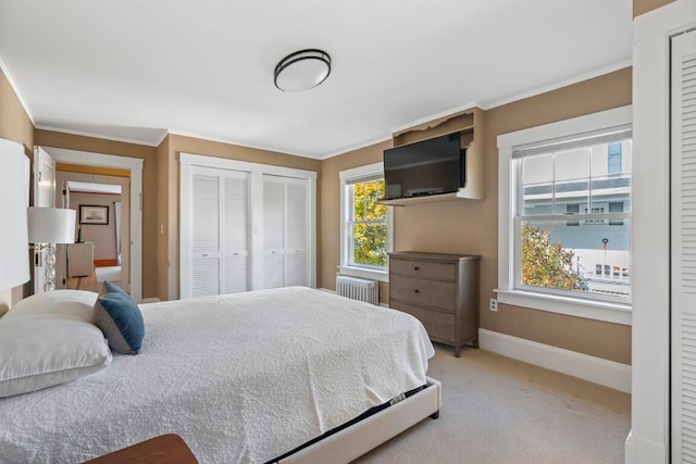 carpeted bedroom featuring ornamental molding, two closets, and radiator