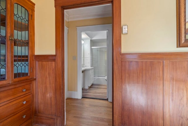 hallway featuring light hardwood / wood-style floors and crown molding