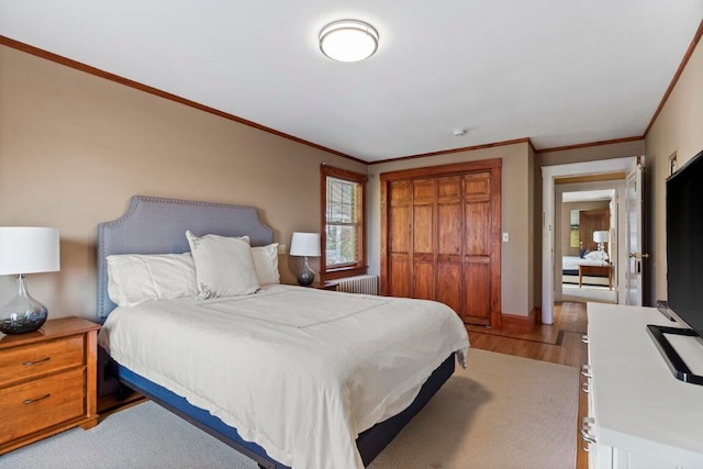 bedroom with ornamental molding, radiator, and light hardwood / wood-style floors