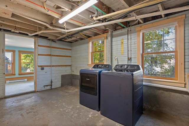 washroom with a baseboard heating unit, a wealth of natural light, and washer and dryer