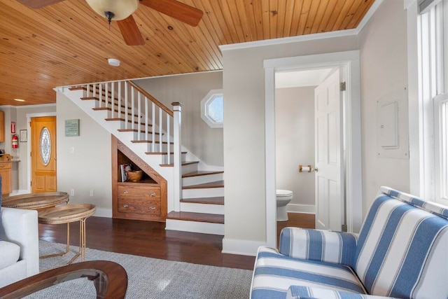 living room featuring dark wood-type flooring, ceiling fan, crown molding, and wooden ceiling