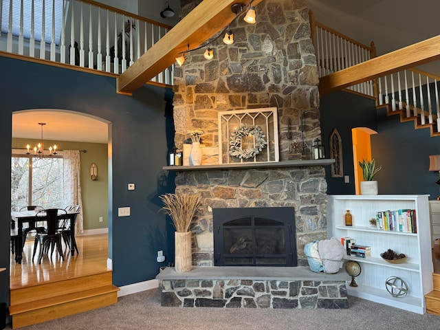 carpeted living room featuring a high ceiling and a fireplace