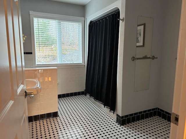 bathroom with tile walls, tile patterned flooring, and walk in shower