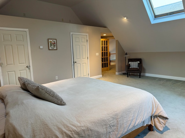 carpeted bedroom featuring lofted ceiling with skylight