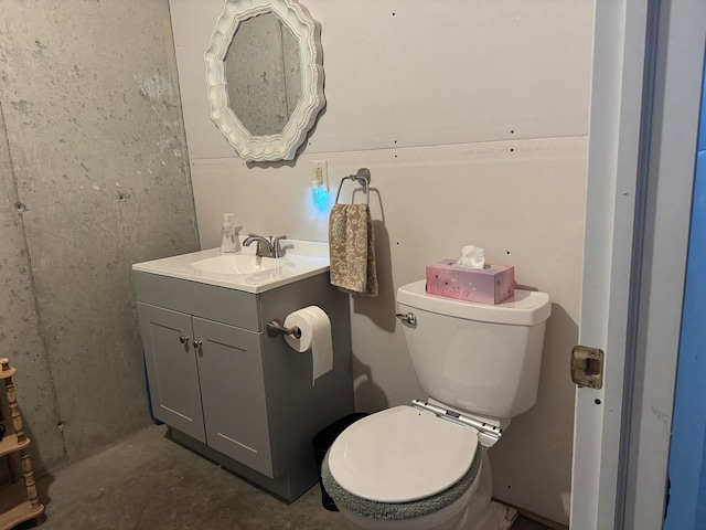 bathroom featuring vanity, toilet, and concrete flooring