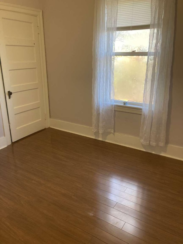 spare room featuring dark wood-type flooring