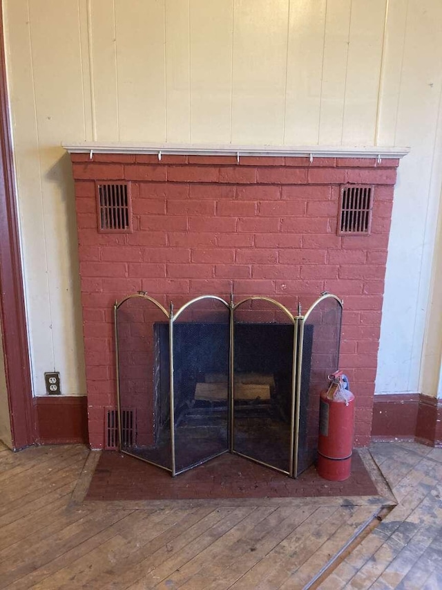 interior details featuring wood-type flooring and a brick fireplace