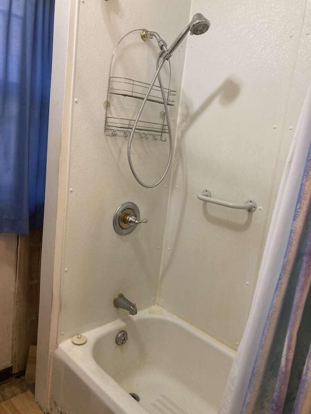 bathroom with hardwood / wood-style floors and shower / tub combo