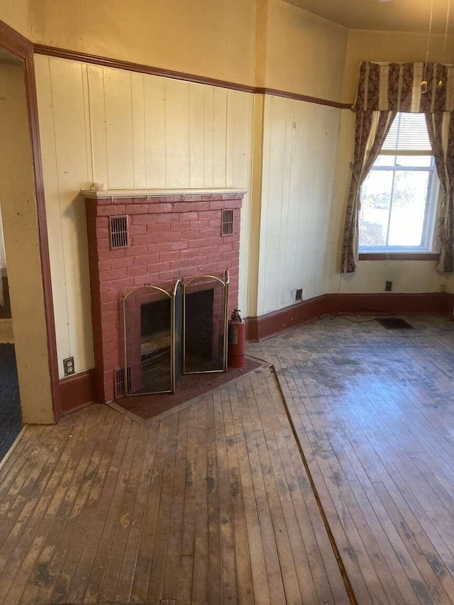 unfurnished living room with wood-type flooring and a fireplace