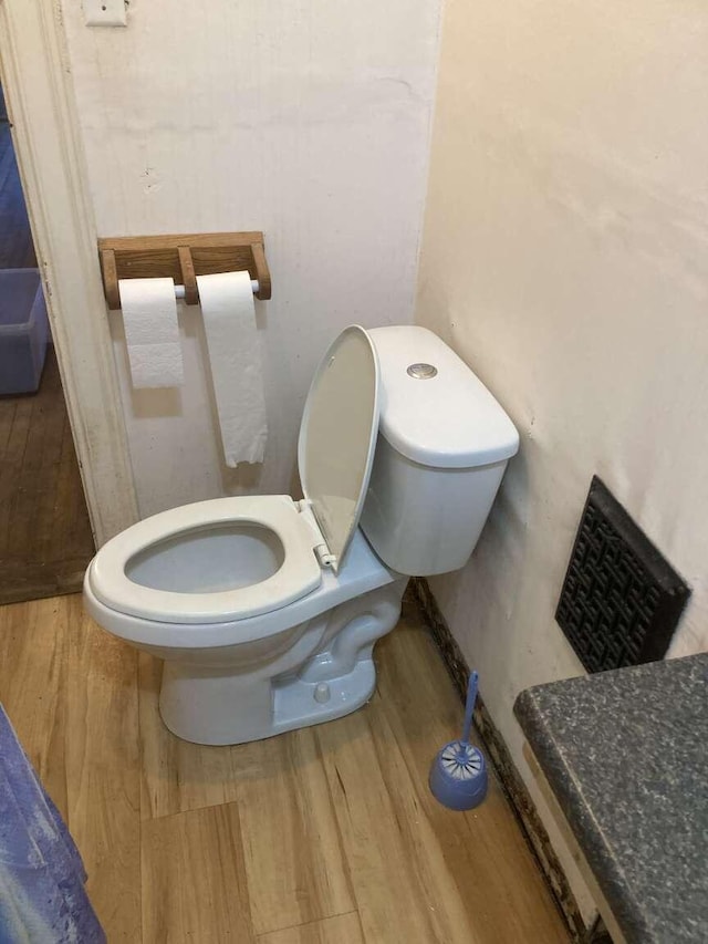 bathroom with hardwood / wood-style flooring and toilet