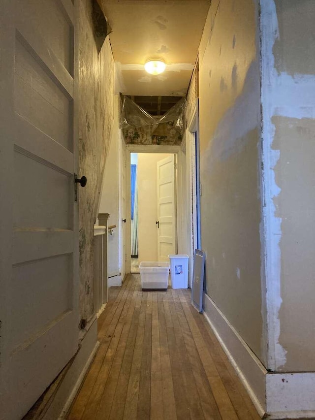 corridor with hardwood / wood-style flooring