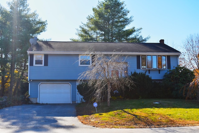 bi-level home with a garage and a front yard