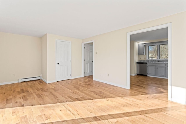 unfurnished room with light wood-type flooring and baseboard heating