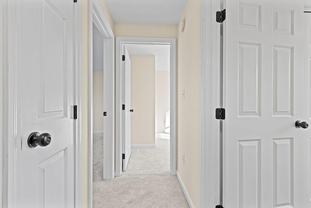 hall with light colored carpet