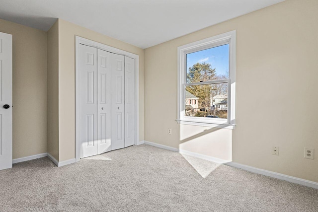 unfurnished bedroom with light carpet and a closet