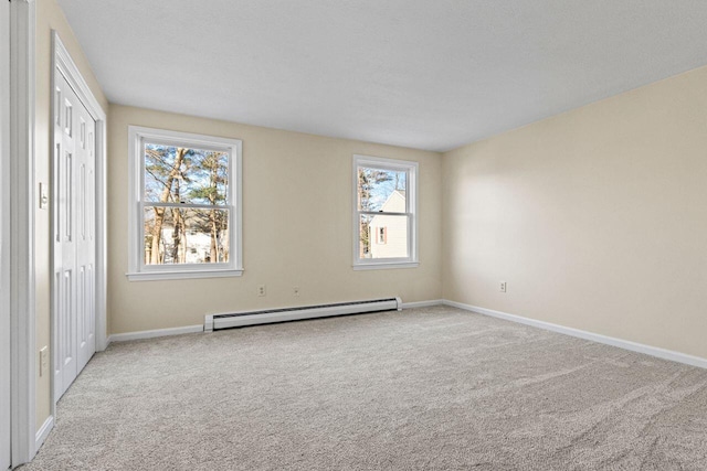 spare room featuring light carpet and baseboard heating