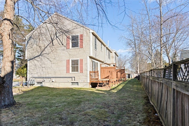 back of property with a deck and a yard