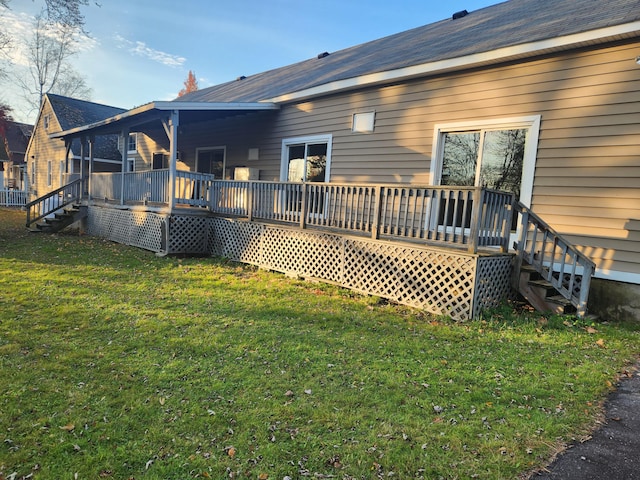 rear view of house featuring a yard and a deck