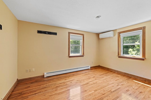 221 Frost Rd, Lyman, ME 04002 - unfurnished room with a baseboard heating unit, a wall unit AC, healthy amount of natural light, and light wood finished floors