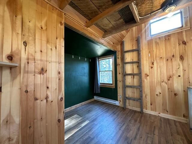 interior space featuring baseboard heating, wooden walls, vaulted ceiling with beams, and dark wood-type flooring