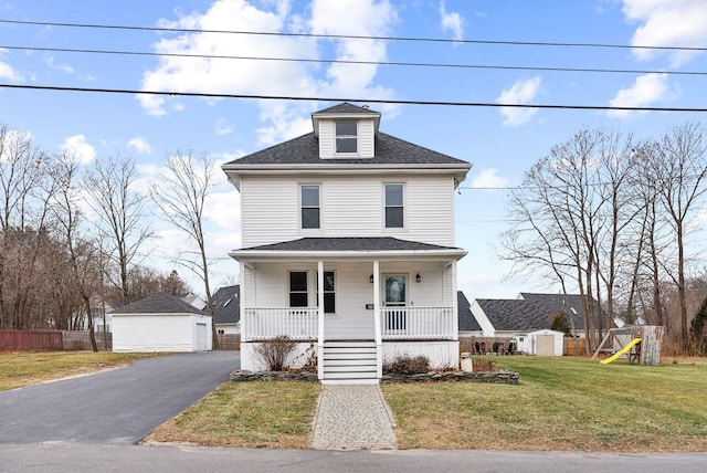 view of front of property with a porch, an outbuilding, a front yard, and a garage