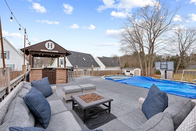 view of swimming pool with a bar, a fire pit, and a storage unit