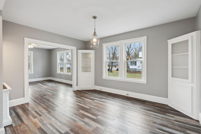 unfurnished dining area with dark hardwood / wood-style floors and ceiling fan