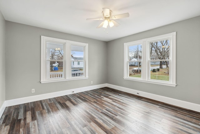 empty room featuring a wealth of natural light, dark hardwood / wood-style flooring, and ceiling fan