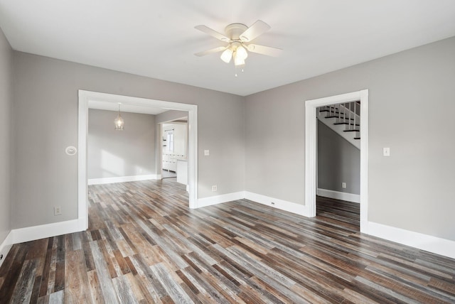 empty room with ceiling fan and dark wood-type flooring