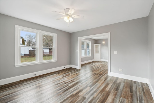 unfurnished room with dark hardwood / wood-style flooring and ceiling fan